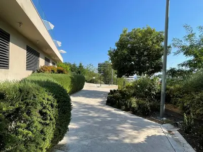 a walk way next to a building with bushes at Status-M Apartments 112 in Becici