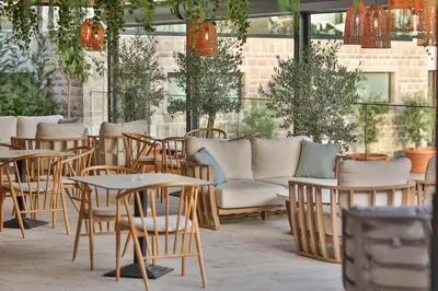 a patio with tables and chairs and a couch at Hotel kingStone Budva in Budva