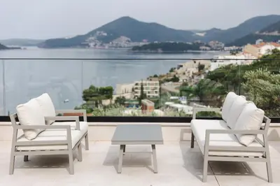 two chairs and a table on a balcony with a view at Hotel kingStone Budva in Budva