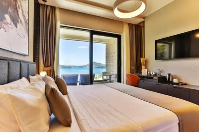a bedroom with a large bed with a view of the ocean at Hotel kingStone Budva in Budva