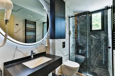 a bathroom with a sink and a shower and a mirror at Hotel kingStone Budva in Budva