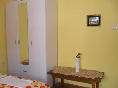 a room with a bed and a table with a mirror at Apartment Batricevic in Ulcinj