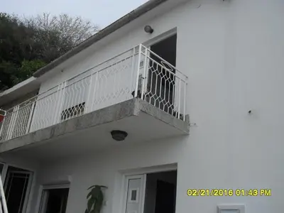 a white building with a balcony on it at Apartment Batricevic in Ulcinj