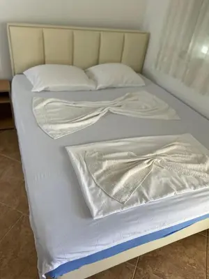 a bed with white sheets and pillows on it at Babulje in Ulcinj
