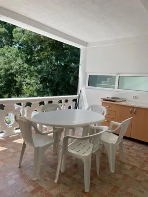 a white dining room with a table and chairs at Babulje in Ulcinj