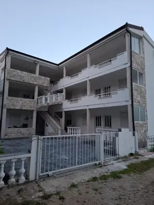 an apartment building with a fence in front of it at Babulje in Ulcinj