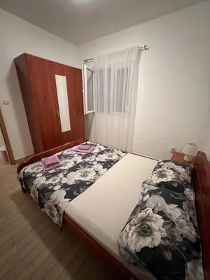 a bedroom with a large bed with flowers on it at MarBis Apartmani near the sea in Utjeha