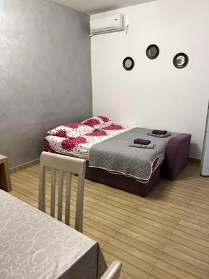 a bedroom with two beds and a table and a table and chairs at MarBis Apartmani near the sea in Utjeha