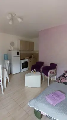 a kitchen and a living room with a table and chairs at MarBis Apartmani near the sea in Utjeha