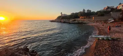 a group of people on a beach at sunset at MarBis Apartmani near the sea in Utjeha