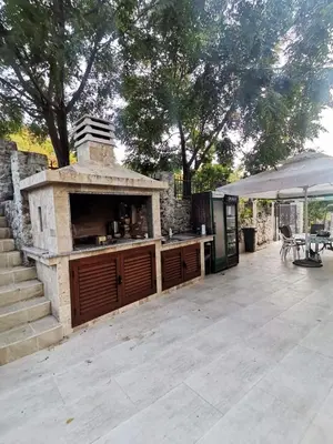 a patio with an outdoor kitchen with a grill at MarBis Apartmani near the sea in Utjeha