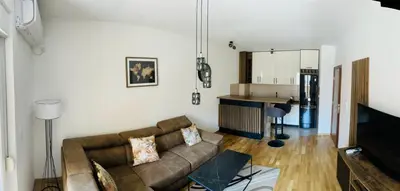a living room with a couch and a kitchen at RB De lux apartment in Podgorica