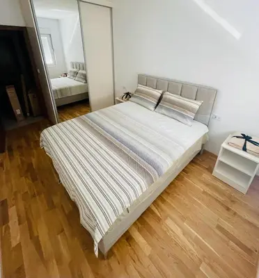 a large bed in a bedroom with a mirror at RB De lux apartment in Podgorica