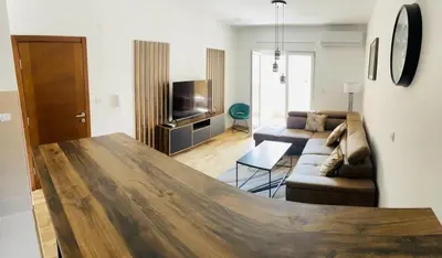 a large wooden table in a living room with a couch at RB De lux apartment in Podgorica
