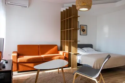 a bedroom with a bed and a couch and a table at The Riverscape in Podgorica