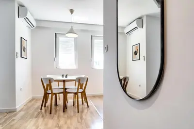a dining room with a mirror and a table and chairs at The Riverscape in Podgorica