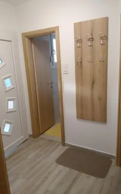 a hallway with a door and a mirror on a wall at M&A Montenegro Apartmani in Golubovci