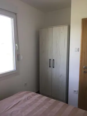 a bedroom with a bed and a cabinet in it at M&A Montenegro Apartmani in Golubovci