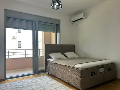 a bedroom with a bed and a window with a balcony at Smakovic Apartments in Ulcinj