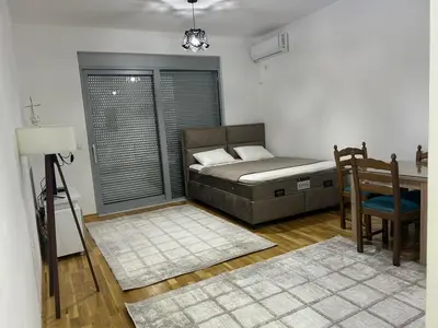 a bedroom with a bed and a table and a chair at Smakovic Apartments in Ulcinj