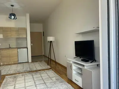 a living room with a television and a kitchen at Smakovic Apartments in Ulcinj