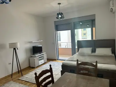 a bedroom with a bed and a table and a television at Smakovic Apartments in Ulcinj