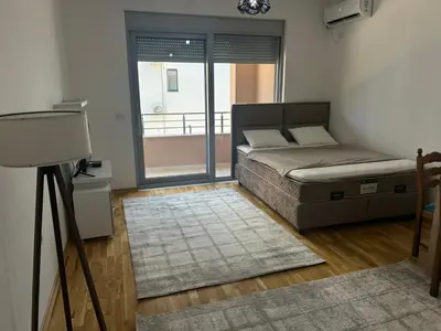 a bedroom with a bed and a view of a balcony at Smakovic Apartments in Ulcinj