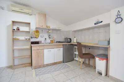 a kitchen with a counter and a chair in it at Apartman 3 in Budva