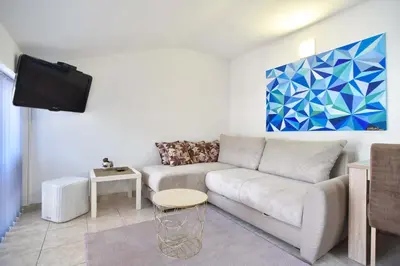 a living room with a couch and a tv at Apartman 3 in Budva