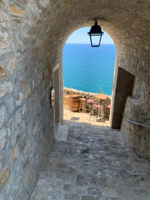 an archway in a stone wall with a view of the ocean at Apartments Zuto in Ulcinj