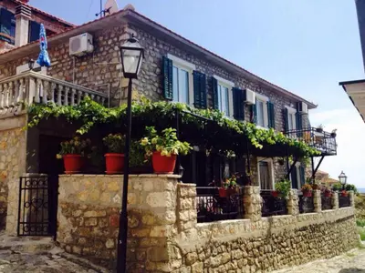 a house with potted plants on a stone wall at Apartments Zuto in Ulcinj