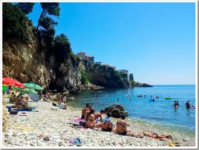 a group of people on a beach near the water at Apartments Zuto in Ulcinj