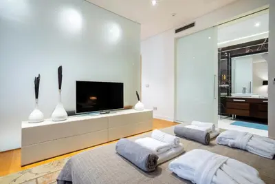 a living room with two beds and a flat screen tv at Luxury Waterfront Villa at Dukly Gardens in Budva