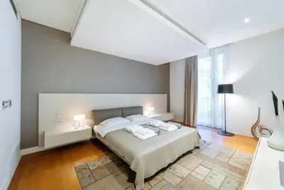 a bedroom with a bed with two lamps on it at Luxury Waterfront Villa at Dukly Gardens in Budva