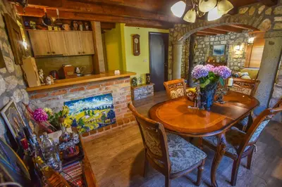 a dining room with a wooden table with flowers on it at Holiday Home Dapcevic in Budva