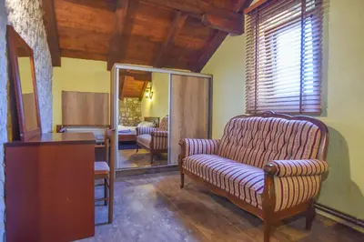 a living room with a chair and a bedroom at Holiday Home Dapcevic in Budva