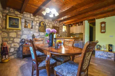 a dining room with a wooden table and chairs at Holiday Home Dapcevic in Budva