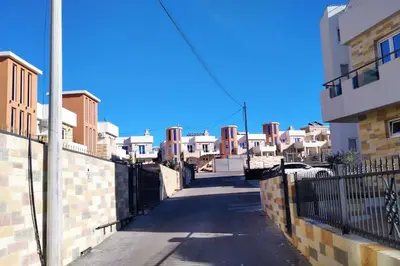 an empty street with white buildings and a fence at Студия для отдыха или проживания in Dobra Voda