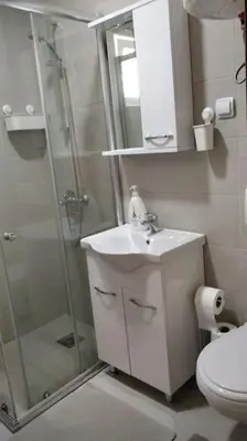 a bathroom with a shower and a sink and a toilet at Студия для отдыха или проживания in Dobra Voda