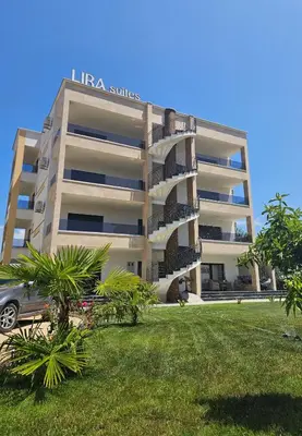a large apartment building with a car parked in front of it at Lira Suites in Donji Štoj