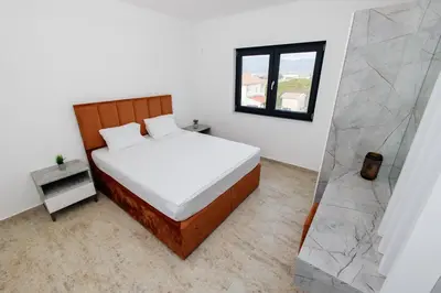 a bedroom with a large bed and a mirror at Lira Suites in Donji Štoj