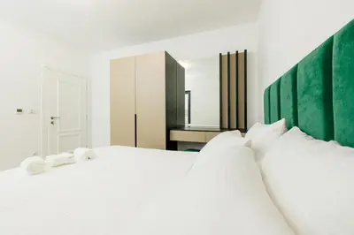 a bedroom with a white bed with white pillows at Lira Suites in Donji Štoj
