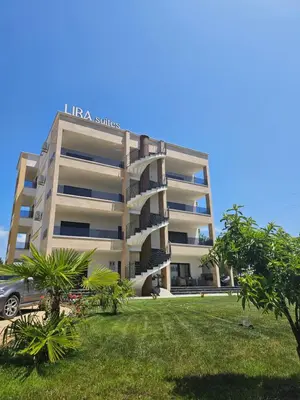 a large building with a car parked in front of it at Lira Suites in Donji Štoj