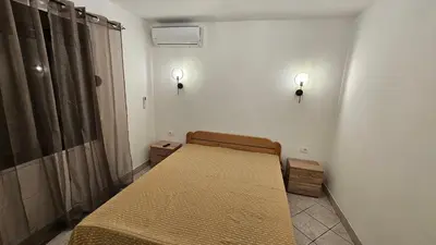 a room with a bed and two lights on the wall at Apartmani Lime in Petrovac na Moru