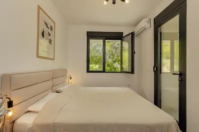 a white bedroom with a bed and a window at Lux Grand Apartment Kotor in Kotor