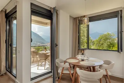 a dining room with a table and chairs and a large window at Lux Grand Apartment Kotor in Kotor