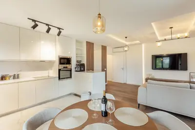 a kitchen and living room with a table and chairs at Lux Grand Apartment Kotor in Kotor