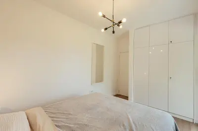 a white bedroom with a bed and a large window at Lux Grand Apartment Kotor in Kotor
