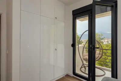 a room with white cabinets and a glass door at Lux Grand Apartment Kotor in Kotor