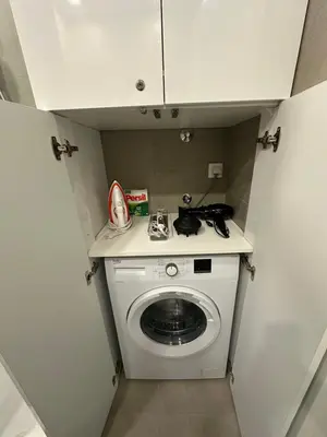 a small kitchen with a washing machine in a room at Studio Apartman Dalia in Budva